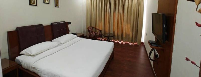 Full view shot of the bedroom of the Suite with golden coloured curtains blocking the natural sunlight - Hotel Gold, Panipat