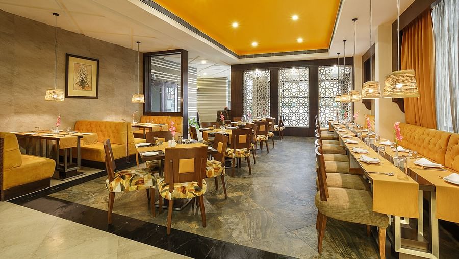 A spacious dining space with wooden chairs and a buffet setup ready to welcome guests for a meal - The Manor, Bareilly