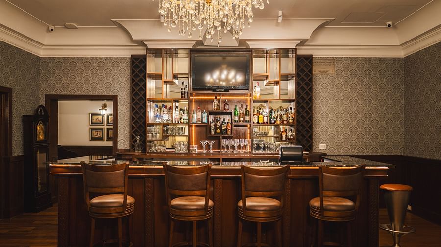 Elegant bar with chandelier lighting, offering a luxurious ambiance at The Claridges Nabha Residence