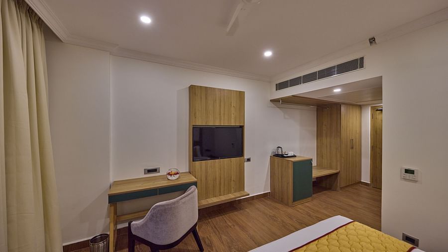 view of the TV and the work desk by the bed - Golden Tulip, Tirupati
