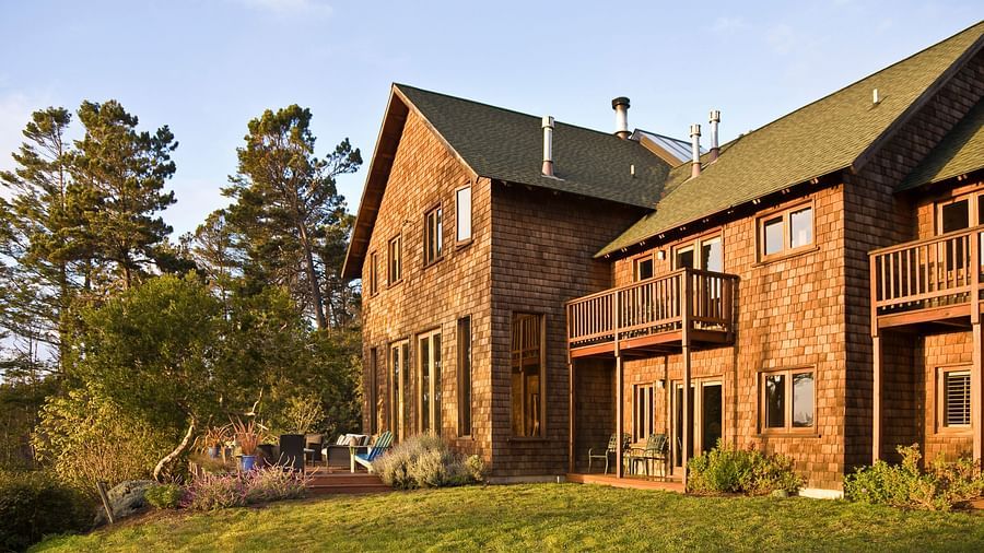 The rear view of Brewery Gulch Inn & Spa with a well manicured lawn and lush green trees