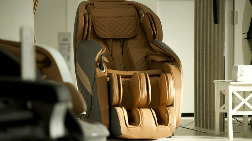 A massage chair with a quilted pattern placed beside a small side table.