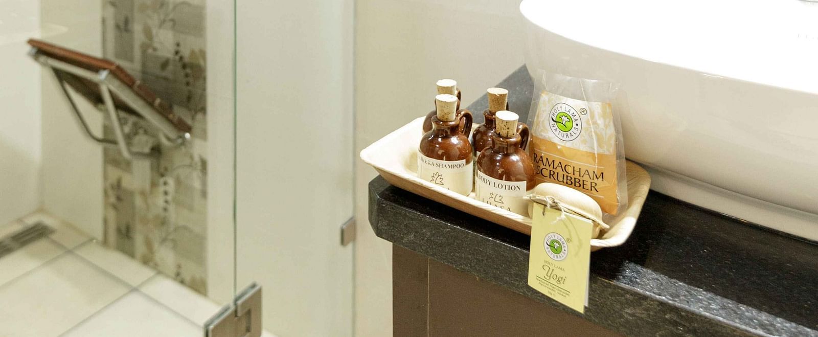 A modern bathroom with a glass-enclosed shower, a white sink, and wooden countertop.