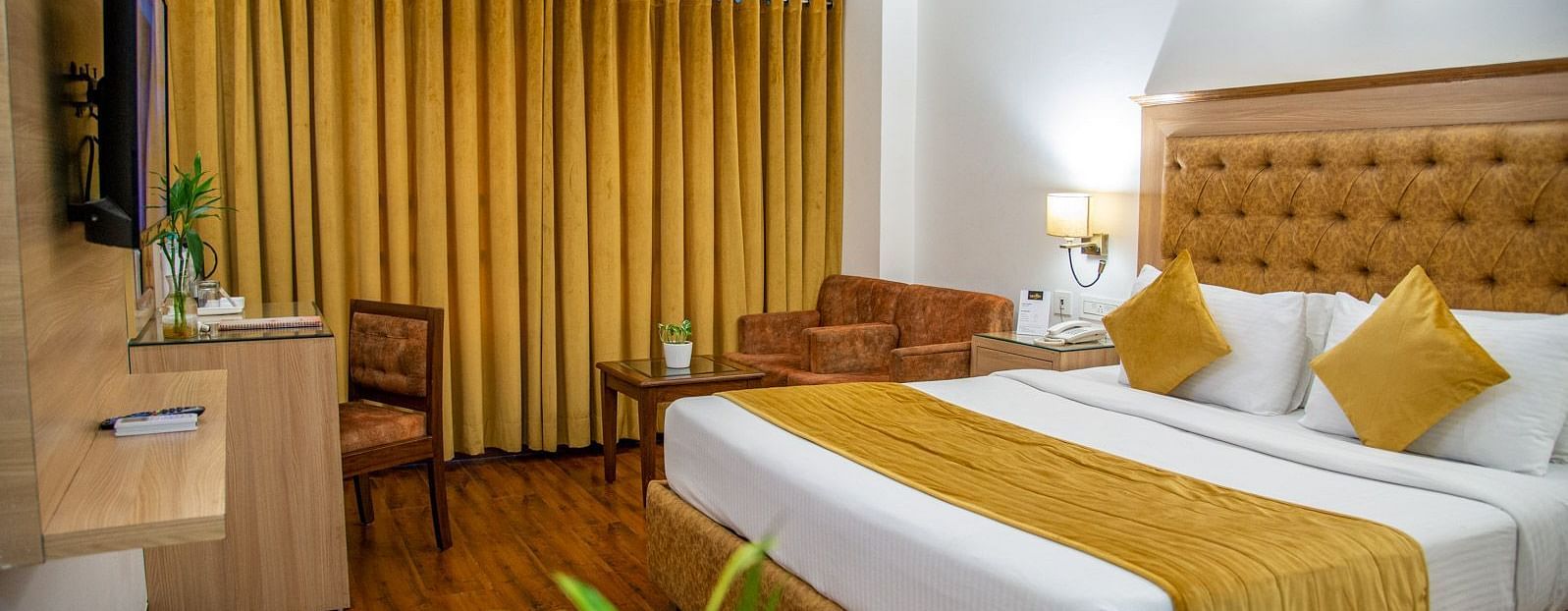 A side view of a room with a bed and TV | Sun Park Hotel & Banquet, Chandigarh - Zirakpur