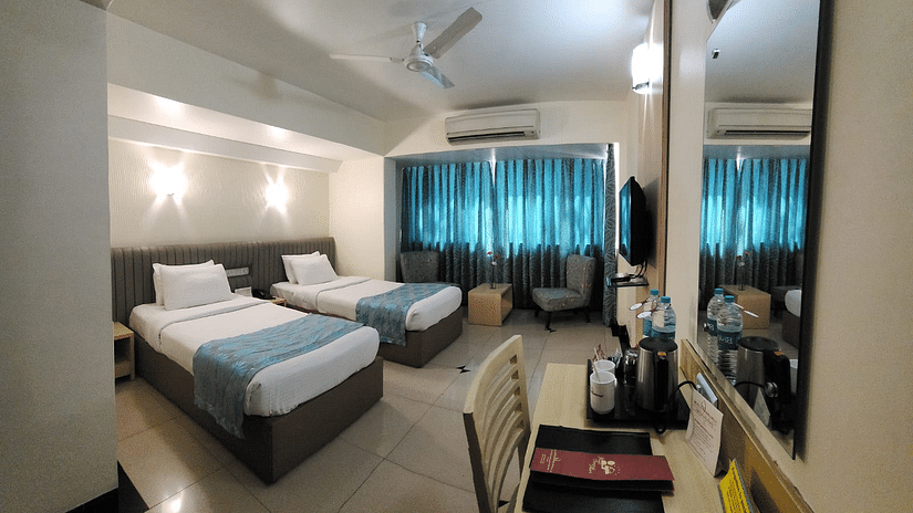 Deluxe room with twin beds and room amenities at Hotel Diplomat