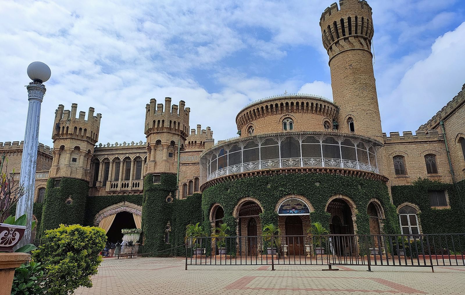 Front view of Bangalore Palace with cloudy sky in the background.