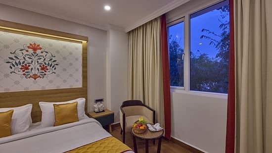 view of a bed and a table and a chair kept beside it - Golden Tulip, Tirupati