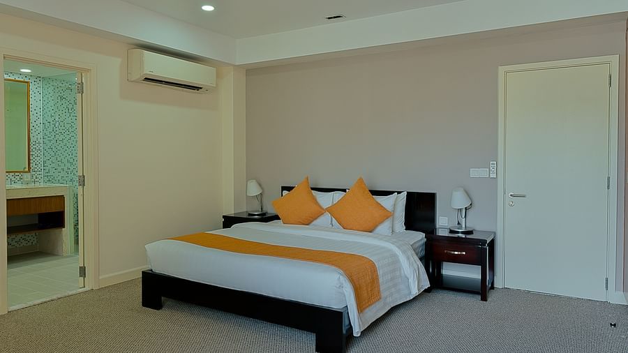 A bedroom with a bed, bedside tables, and AC | Penthouse | Central Mansions, Phnom Penh