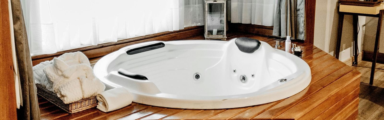 A wooden frame with two steps leading to a bathtub which is kept ready for spa session