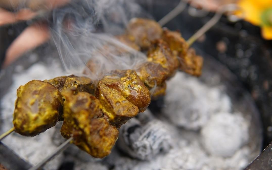 A meat skewer being roasted on a barbeque - Saraca Hotel, Lucknow.