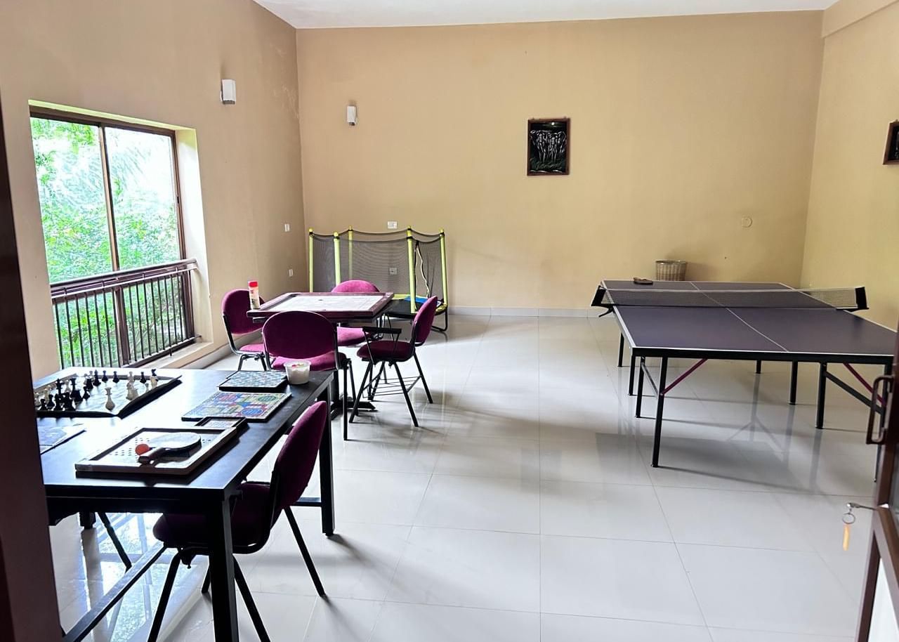 The indoor games room at Paradise Wild Hills Resort, Kollur, with a table tennis table and tables for board games.