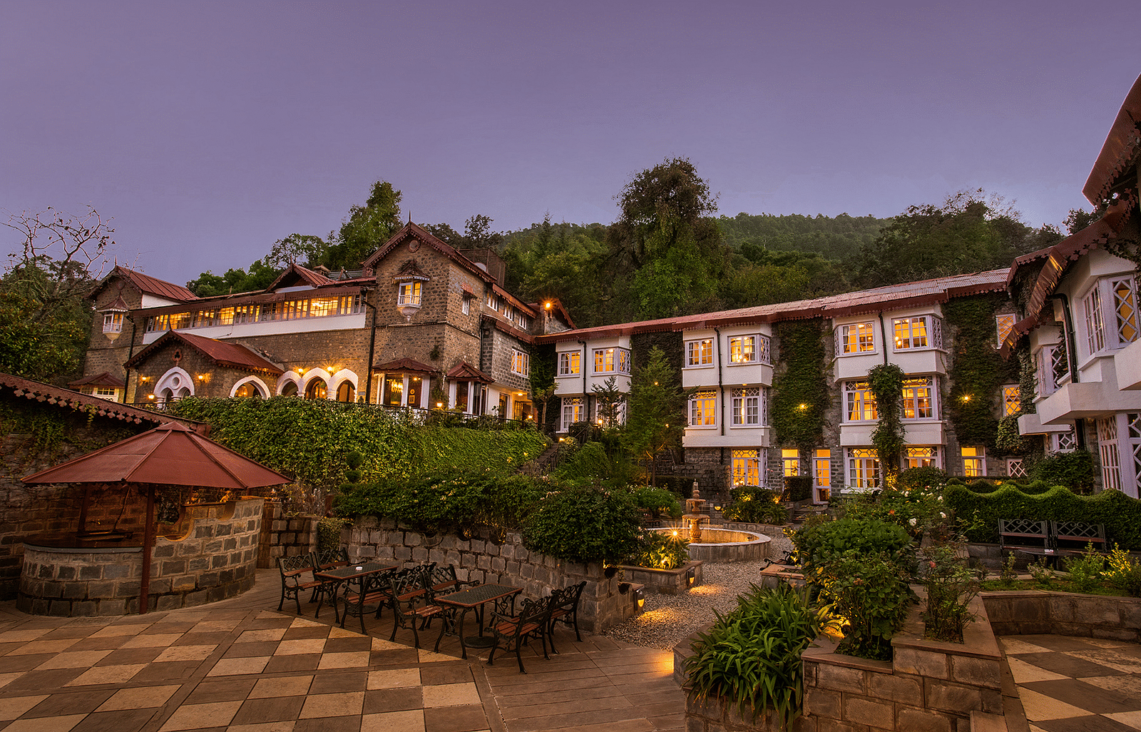 Front view of hotel facade with pathway, surrounded by greenery.