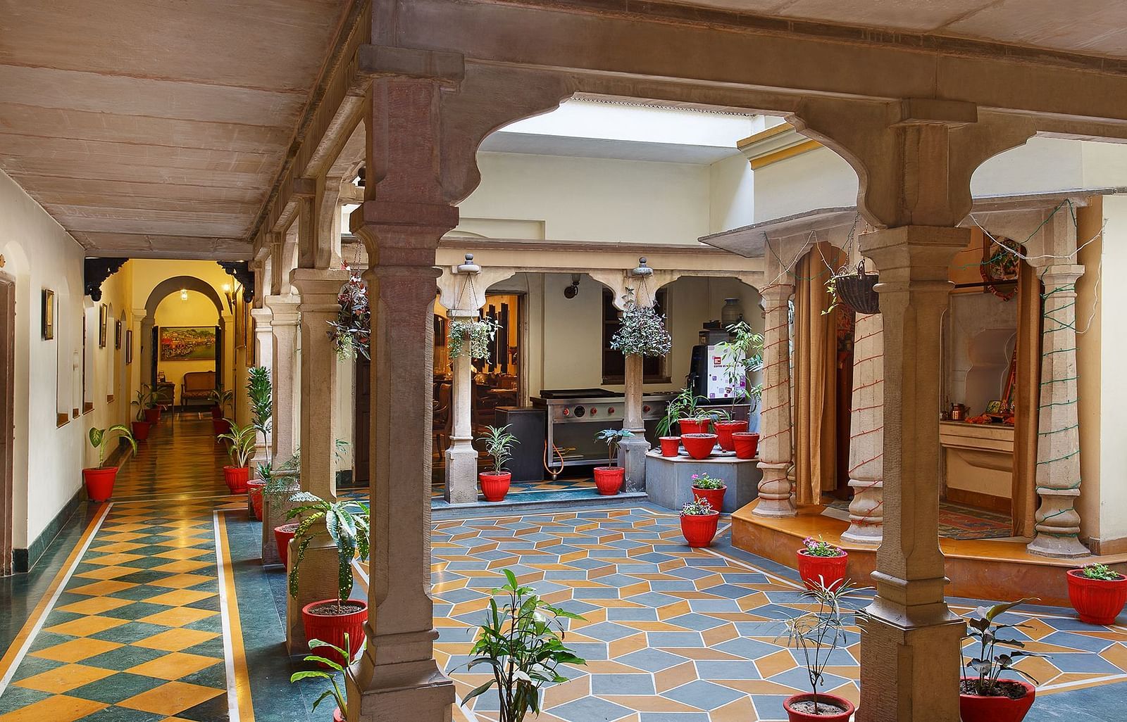 Hotel pathway lined with small potted plants at the corners.