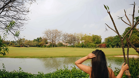 A person standing by a lake with trees in the background, photographed at Karma Chalets.