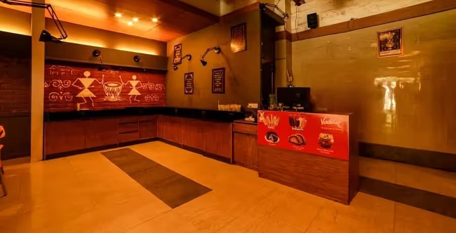 View of the entrance area with warm lighting to Mumbai Masala Restaurant - Max Hotel Prayagraj.