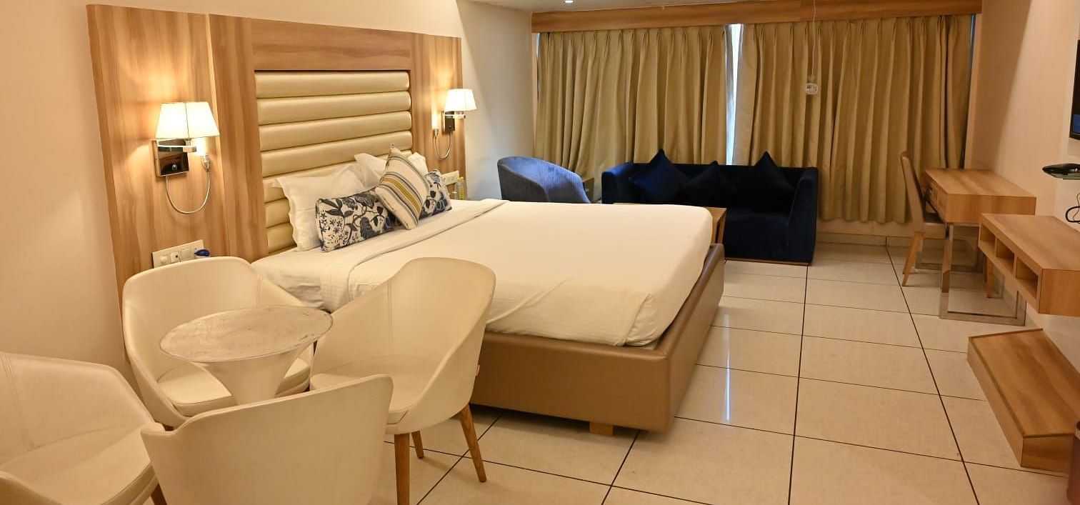 Unique hotel room design at Rang Lords Inn, with a bed, seating, and distinct wooden paneling for a modern touch
