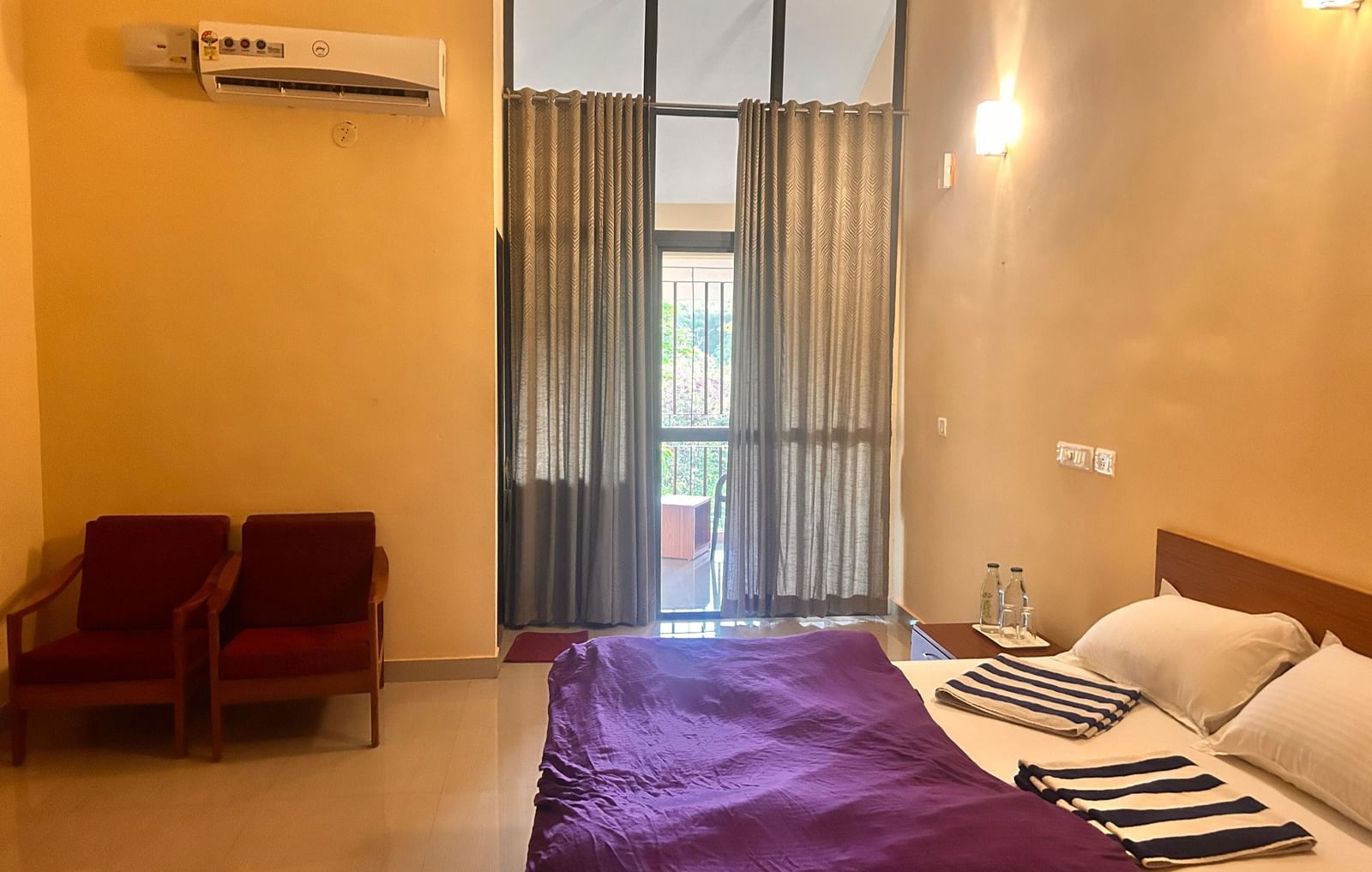 A clean, comfortable room at Paradise Wild Hills Resort, Kollur, with a large bed and a seating area.