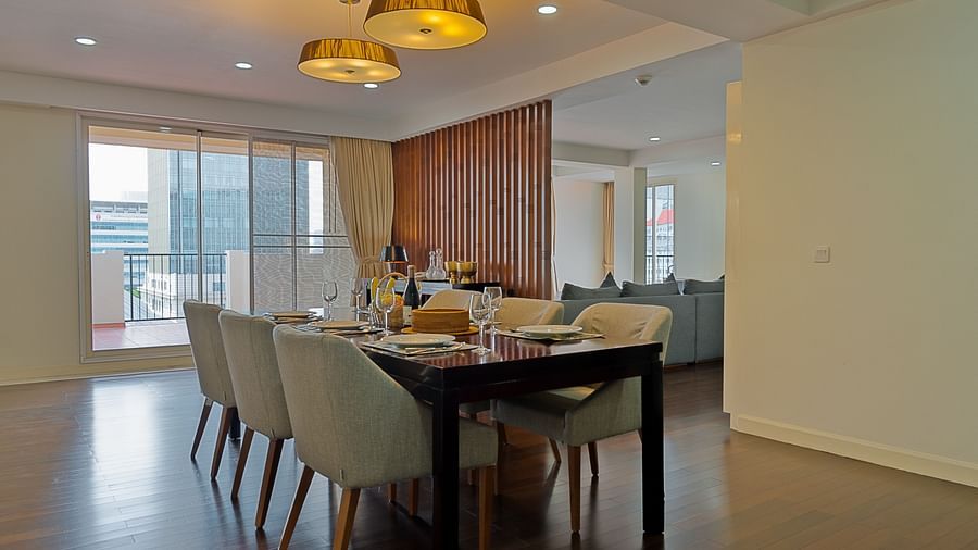 A dining room with a long table, multiple chairs, and a chandelier | Penthouse | Central Mansions, Phnom Penh