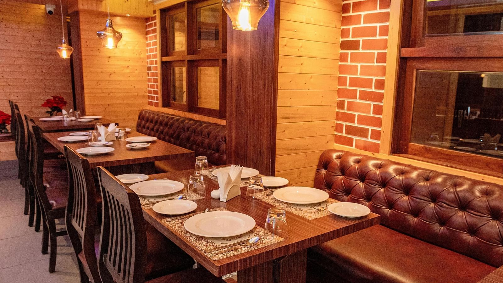 Corner view shot of the restaurant at Sumitel, Sanderling featuring a dining table with well arranged plates and cutlery.