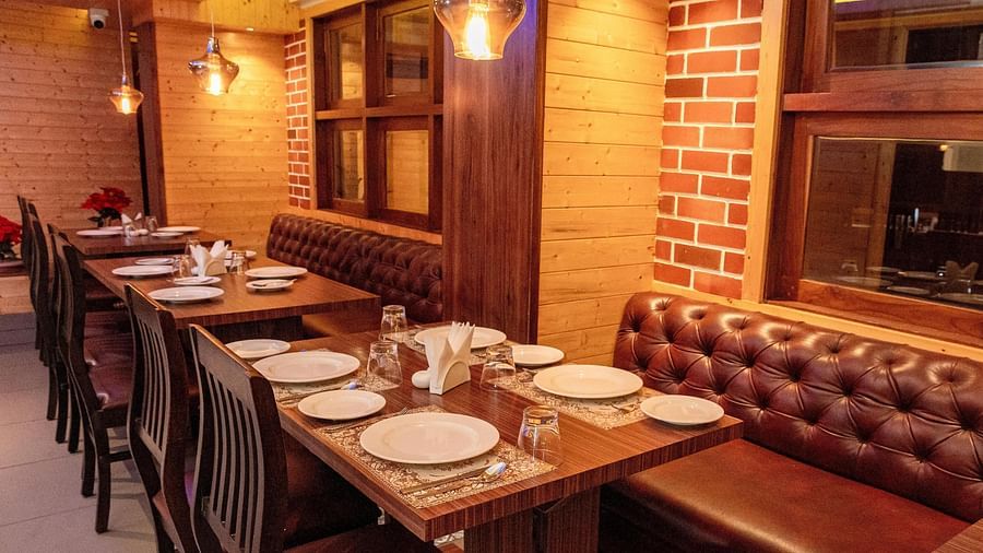 Corner view shot of the restaurant at Sumitel, Sanderling featuring a dining table with well arranged plates and cutlery.