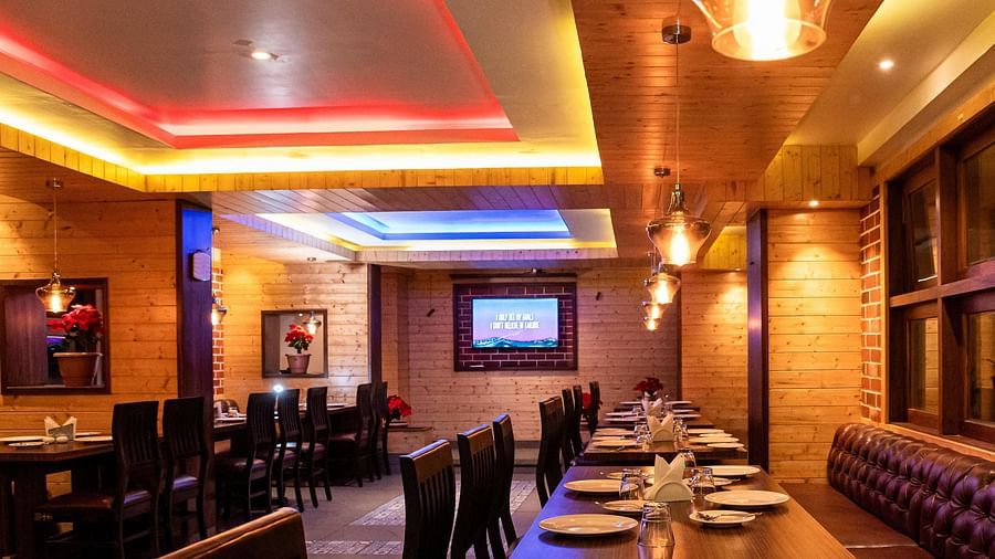 Full view shot of the interiors of a warmly lit restaurant with a television at the end at Sumitel, Sanderling.