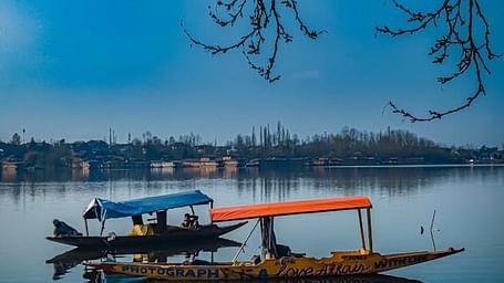 Two boats on a lake with trees in the background.