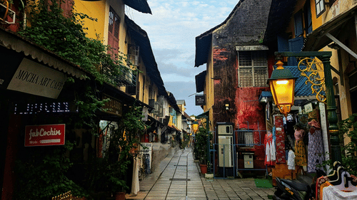 Narrow heritage street lined with traditional shops and old-style architecture.