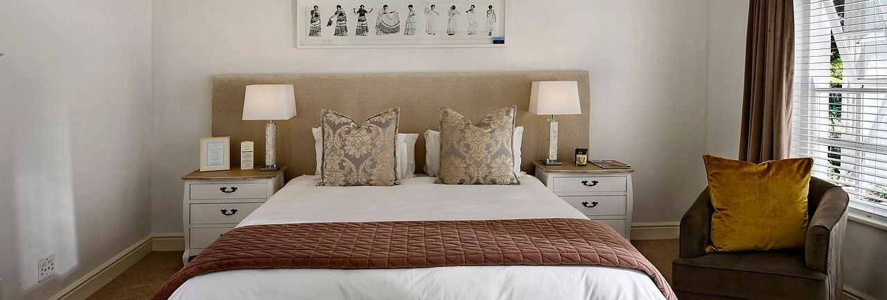 A double bed with a ceiling fan hanging over it in a bedroom.