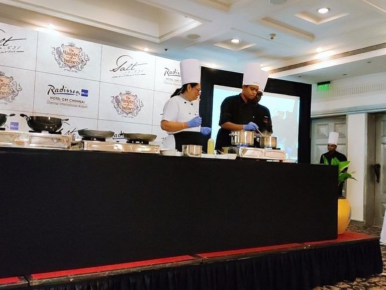 Culinary competition or demonstration on a stage with chefs presenting.