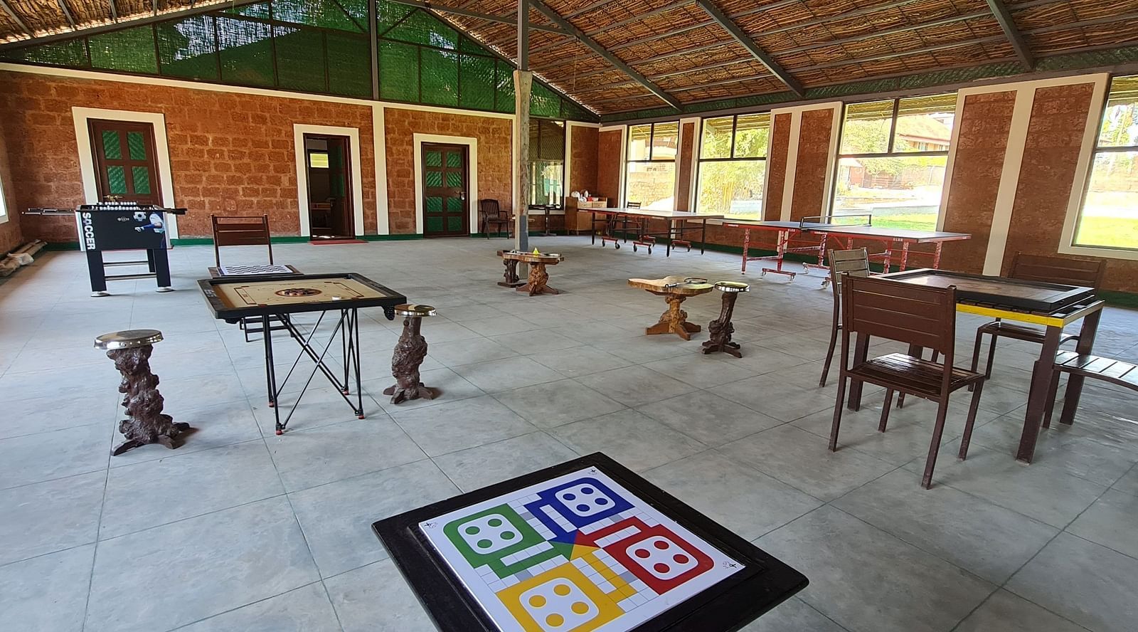 image of the game area with board games like ludo and carom in the activity area at hoysala village resort, hassan