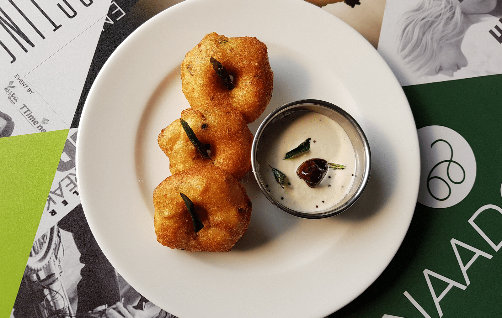 vada and chutney platted on a white plate and kept on a table