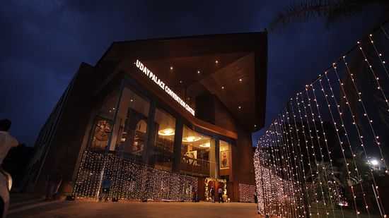 Facade of the wedding hall at Uday Palace Convention Centre lit up with golden fairy lights at night