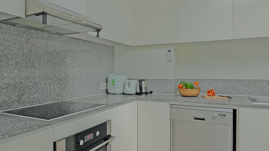 A view of a kitchen with white cabinets, a sink, and a stainless steel stove | Penthouse | Central Mansions, Phnom Penh