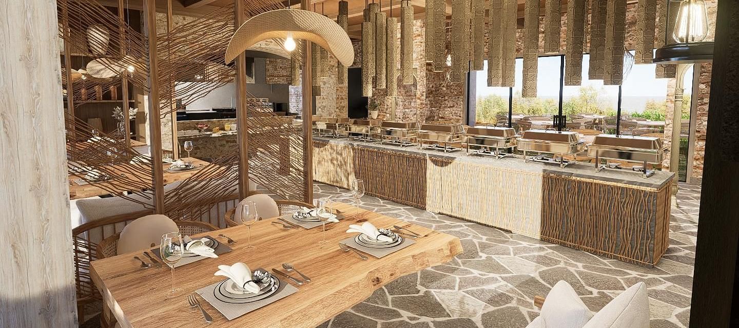 Diagonal view of the restaurant with neatly set tables and chairs, featuring a central table with a buffet setup at The Evren, Vagator.