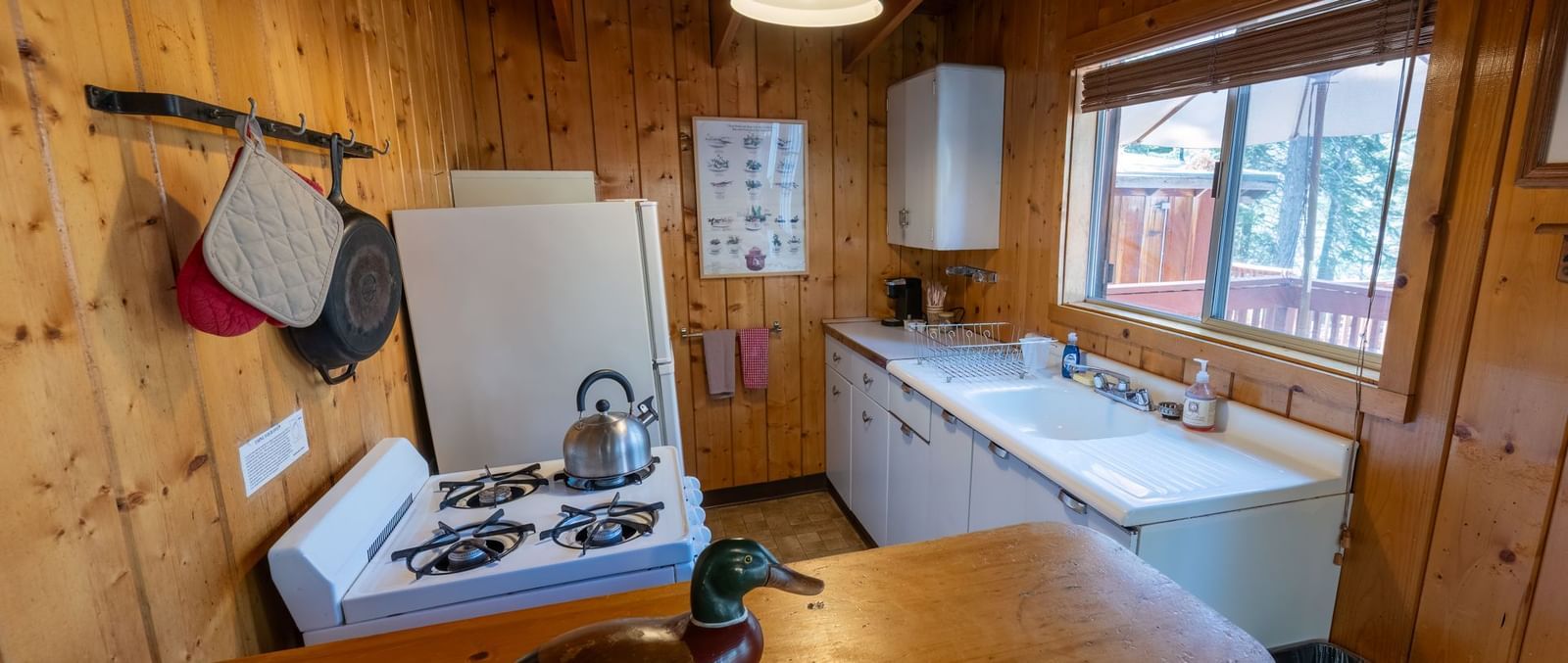 Compact wooden kitchen with stove and sink at Kit Carson Lodge.