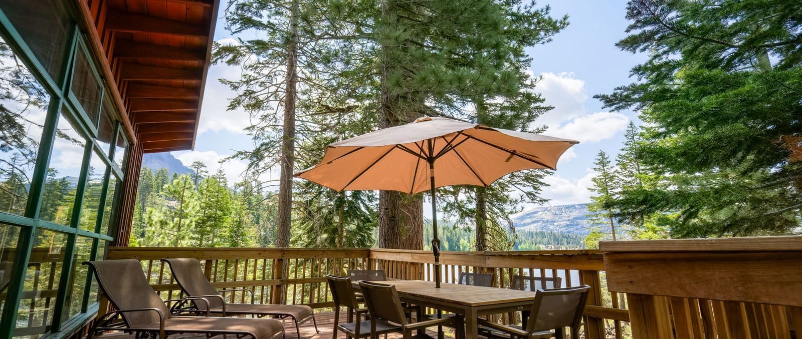 Outdoor deck with patio furniture and forest views at Kit Carson Lodge.
