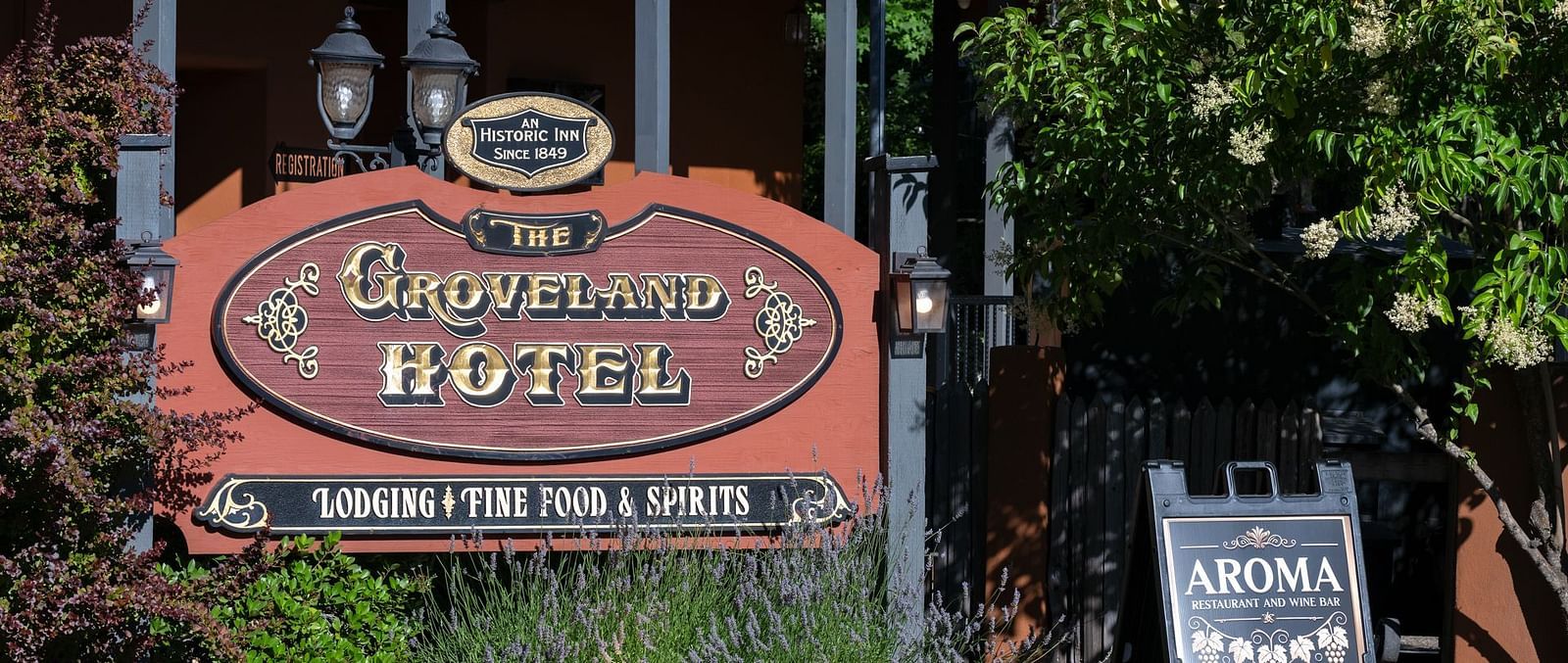 Exterior view of the entrance sign and garden at The Groveland Hotel.