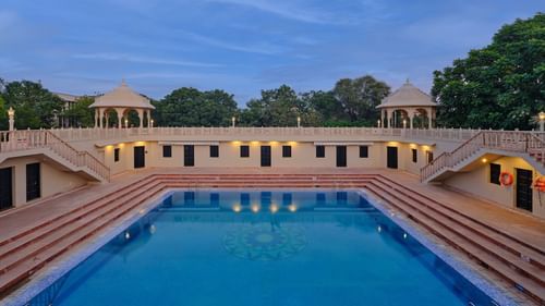 Image of a large swimming pool surrounded by staircase to the pool at Pride Amber Vilas Resort Jaipur