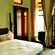 A room with a large bed, spreads, pillows, and windows. | Hotel Devnadi, Haridwar
