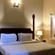 A room with a large bed, spreads, pillows, and lights. | Hotel Devnadi, Haridwar