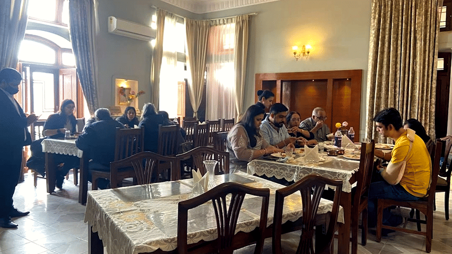 Hotel Devnadi, Haridwar | A dining space with chairs, tables, and a fan.