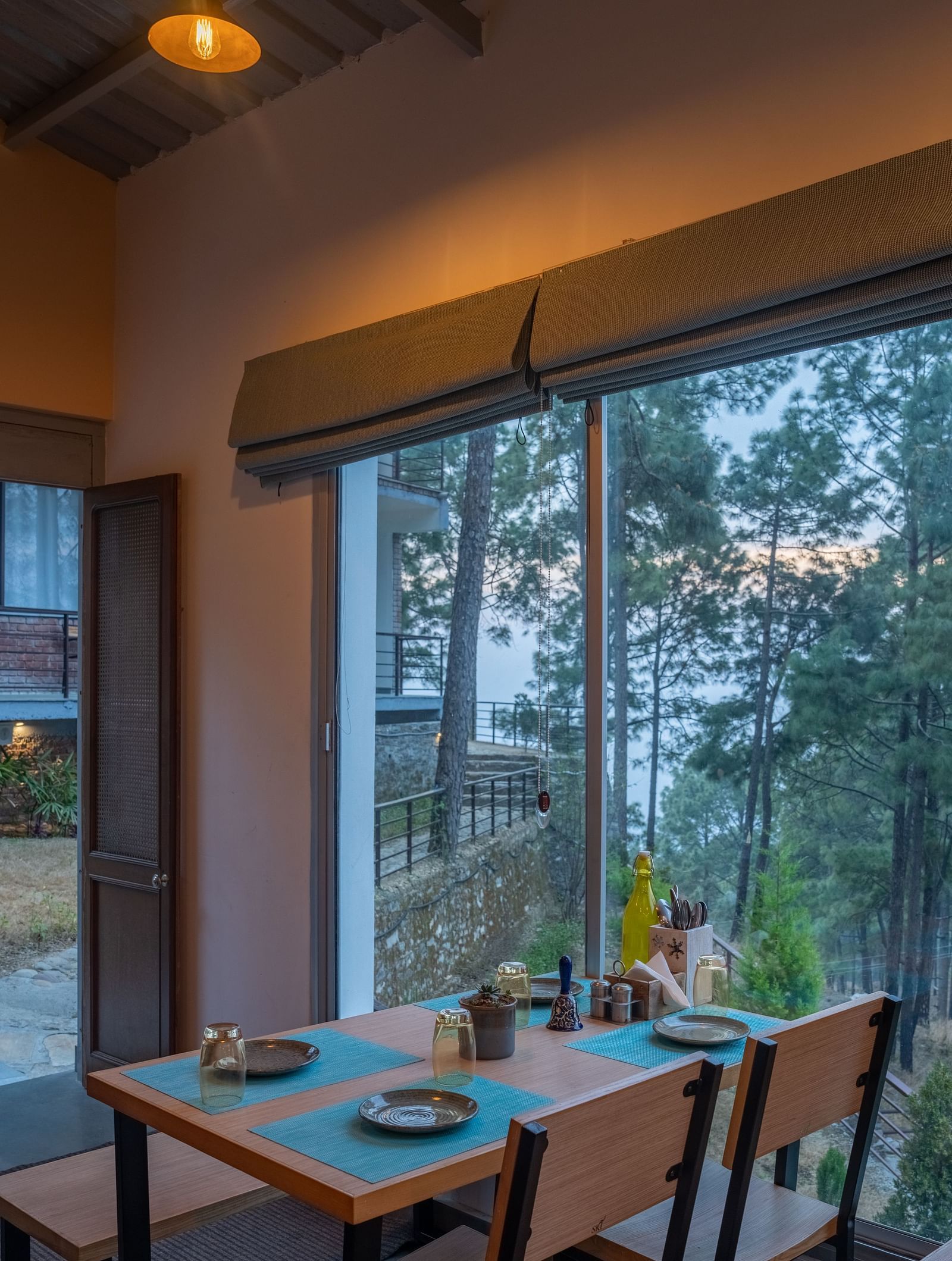 A restaurant with a large glass window beside it, offering a view of the interior dining area at BluSalzz Escapade Resort, Lansdowne