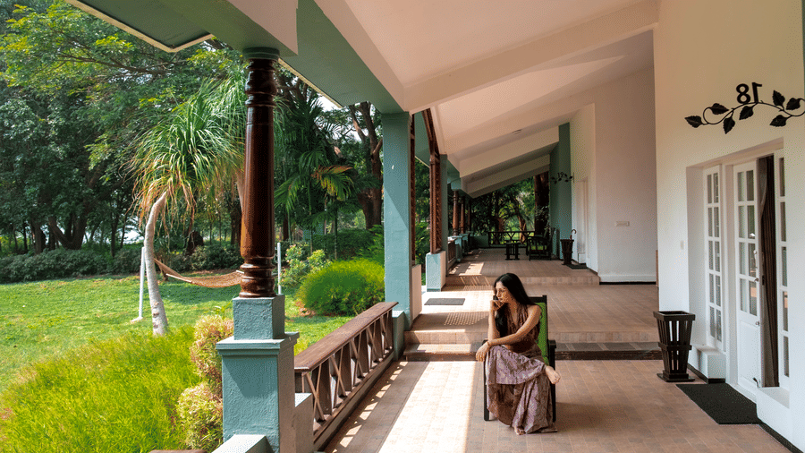 The Waterfront Verandah at The Serai Kabini features a covered outdoor seating area overlooking the garden and pathway.