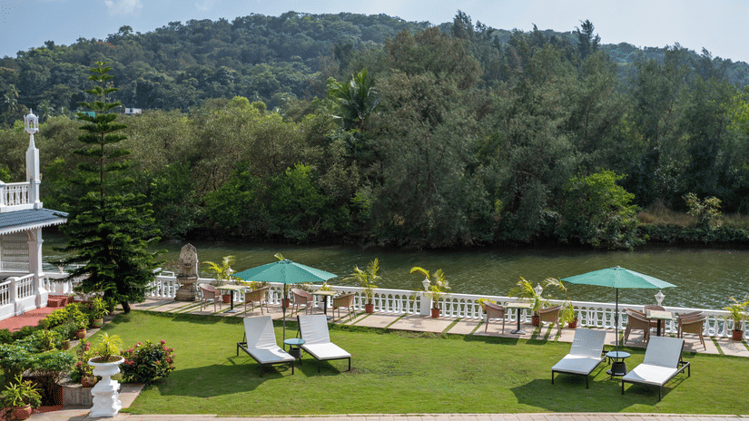 The outdoor premises of the hotel is exposed to lush green hills - Stone Wood Riverfront Resort, Siolim
