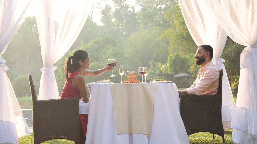 Couple enjoying a private outdoor candlelit dinner at Evolve Back Coorg