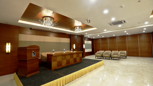a desk with sofas on the podium inside the Banquet hall - VITS Devbhumi, Dwarka