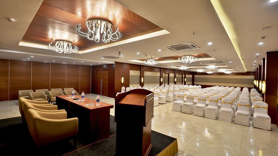 Theatre style seating arrangements with a desk & sofas on the podium inside the Banquet hall - VITS Devbhumi, Dwarka