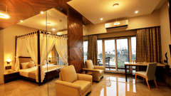 Overview of the Suite Room with a king bed, single seater sofas next to a marble wall - VITS Devbhumi, Dwarka