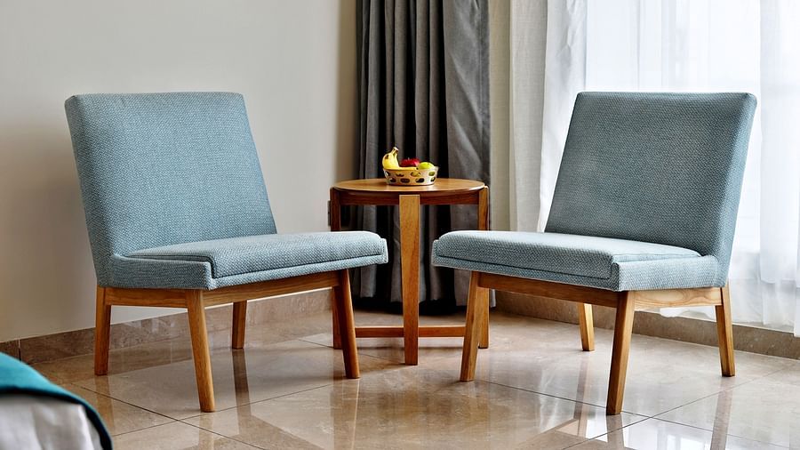 Single seats with a small table next to a bed inside the Deluxe Room - VITS Devbhumi, Dwarka