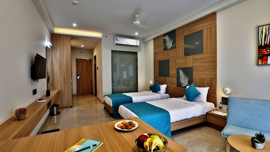 Overview of the Deluxe Room with twin beds, a wall mounted tv and art work above the beds - VITS Devbhumi, Dwarka
